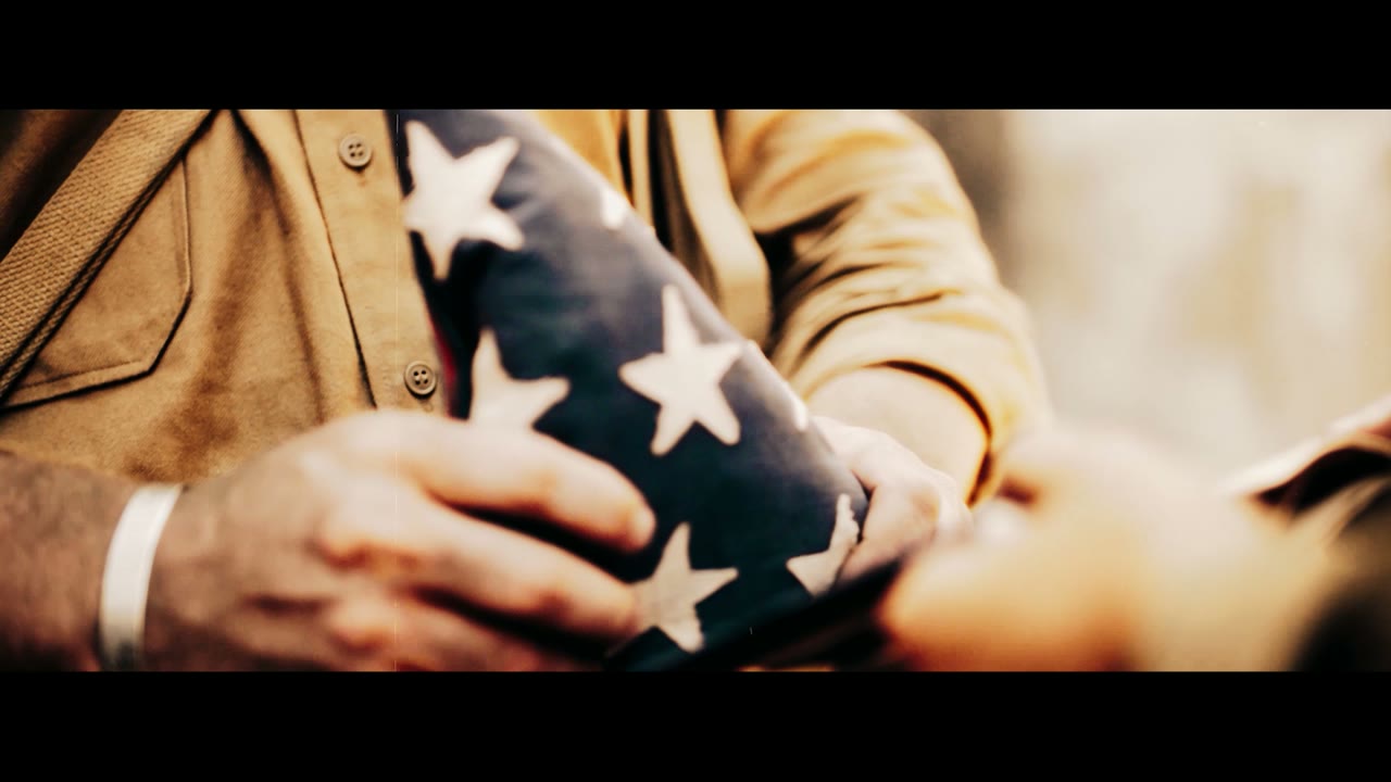 A folded American Flag, held with honor — a still from the official Sojourn 250 film.